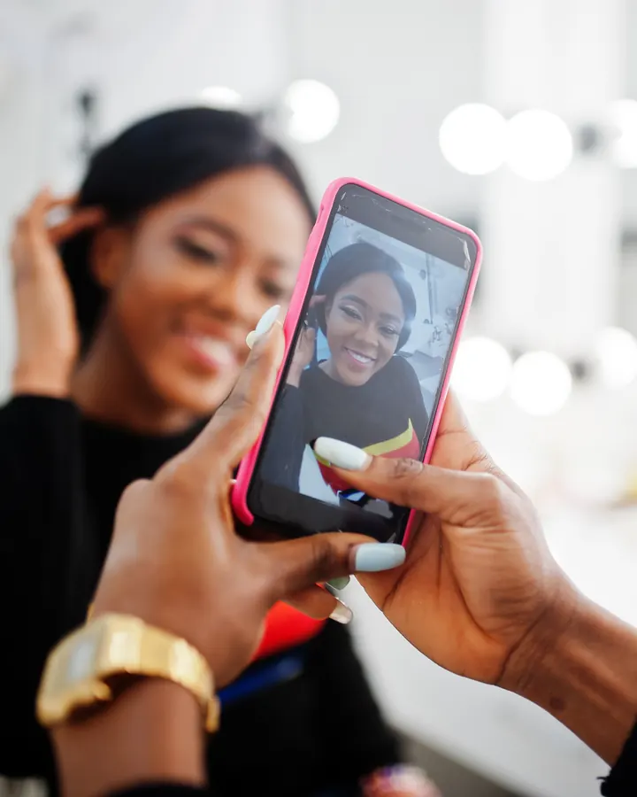 A makeup artist photographing her client's finished look